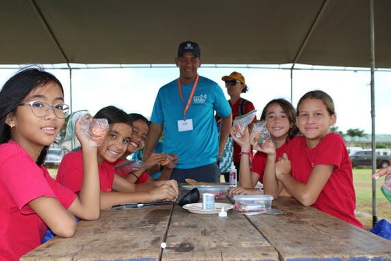 King Kaumualii Elementary students at the Make a Splash Festival with DOW's Ryan Fu (center) who assists with the Project WET activity.